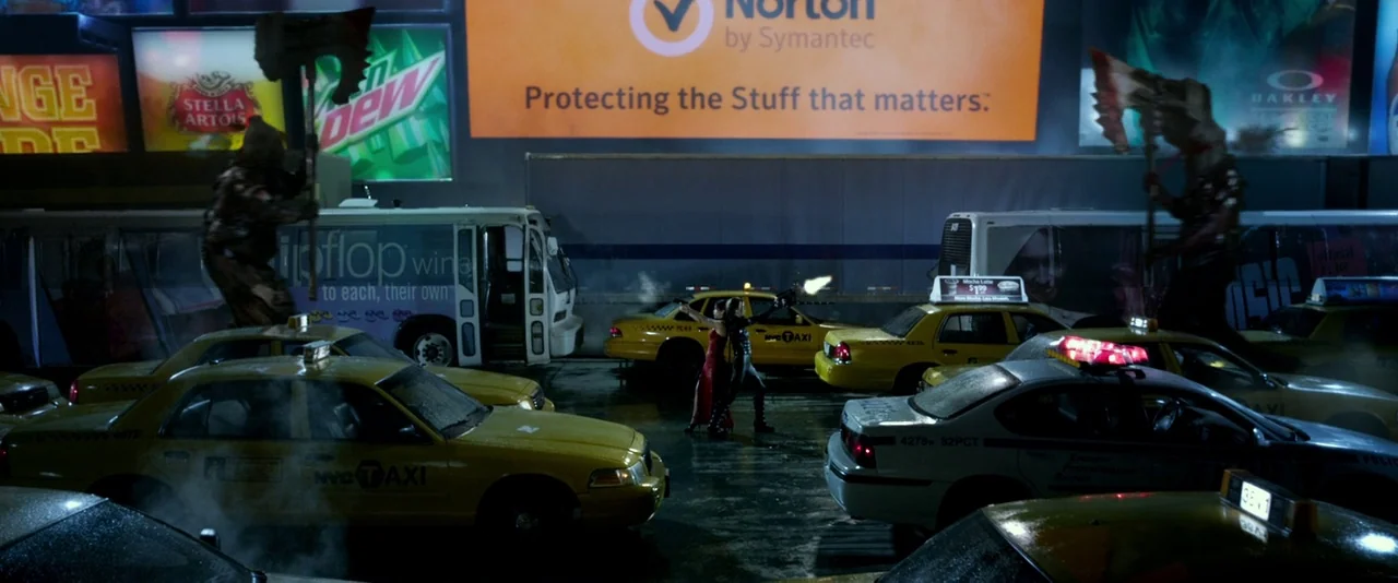 Resident Evil: Retribution (2012) movie still: wide — A nighttime urban intersection is filled with yellow taxis and large advertising billboards…