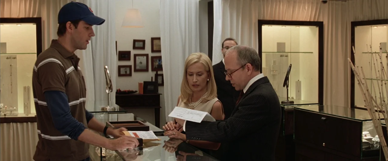 License to Wed (2007) movie still: medium — A high-end retail jewelry store interior features glass display cabinets and white fabric curtains.…