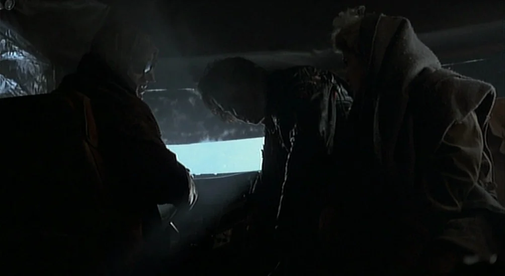 Near Dark (1987) movie still: medium — The dark interior of a vehicle shows three people silhouetted against a rear window. Bright light filters…
