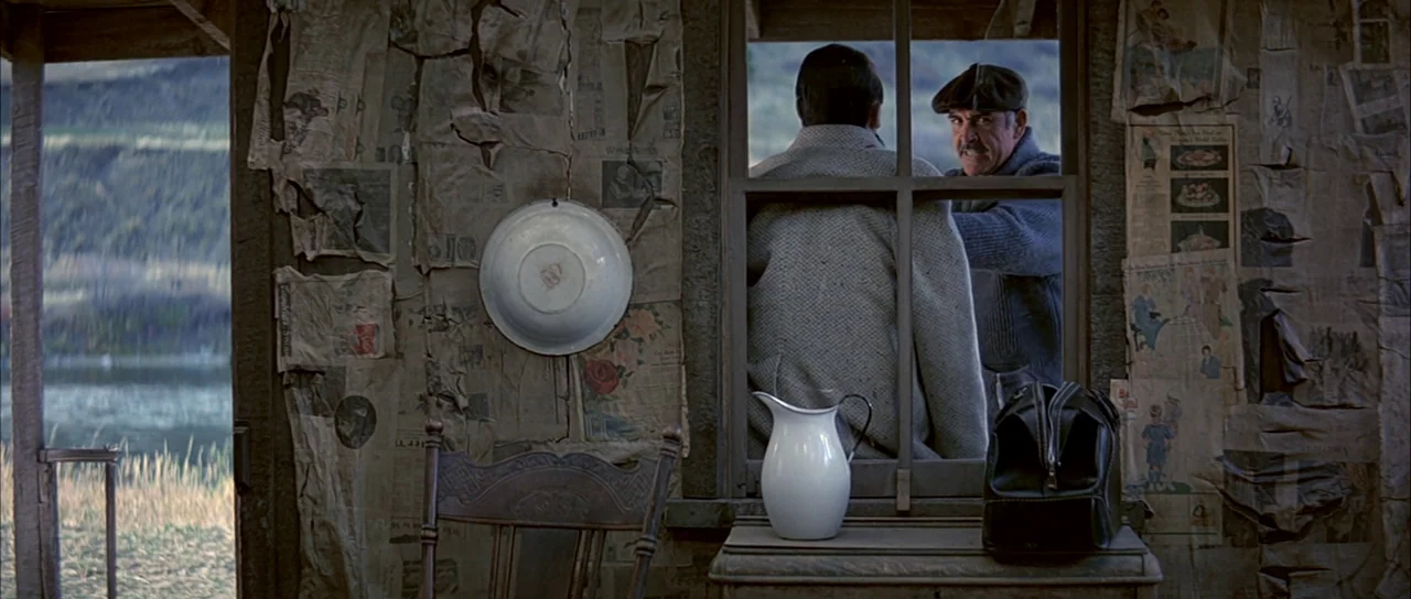 The Untouchables (1987) movie still: medium — The interior walls are covered in layered, tattered newspaper pages with a white basin mounted…