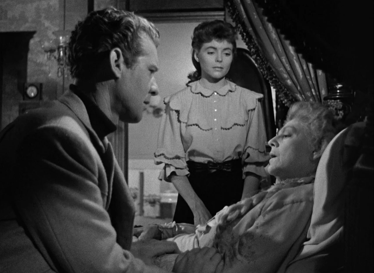 The Spiral Staircase (1946) movie still: medium — A dimly lit room containing an antique bed and period furniture pieces. A man and young woman…