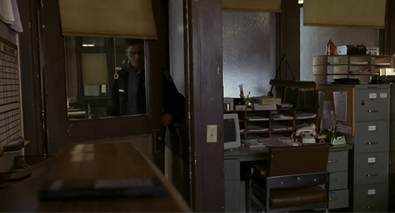 Ladder 49 (2004) movie still: medium — A dated office interior features a wooden desk, metal filing cabinets, and office supplies. A young man…
