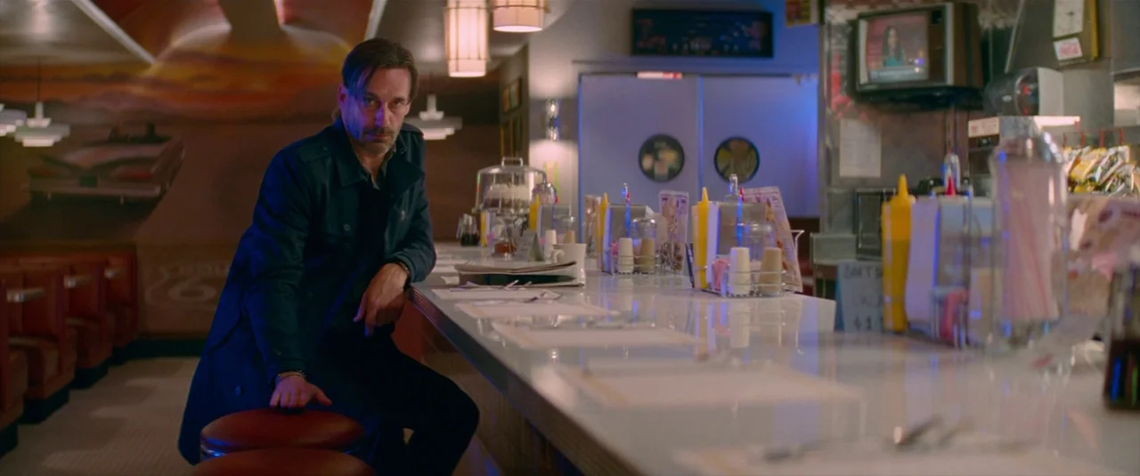 Baby Driver (2017) movie still: medium — A quiet diner counter area features a long reflective white surface and red vinyl booths. A middle-aged man…