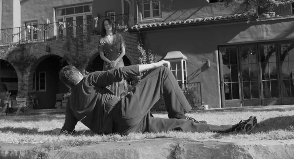 Much Ado About Nothing (2012) movie still: fullbody — A manicured backyard features a large two-story stucco house with arched colonnades and…