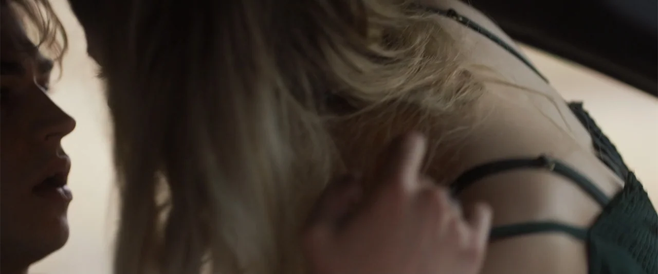 After Ever Happy (2022) movie still: closeup — A close view shows the shoulder and back of a woman near a man. The man leans in towards the woman…