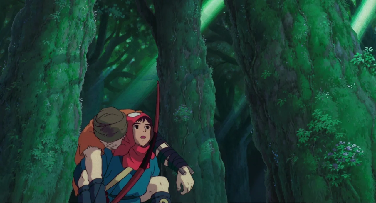 Princess Mononoke (1997) movie still: medium — A dense woodland setting features massive, ancient trees covered in thick layers of moss. A young man…