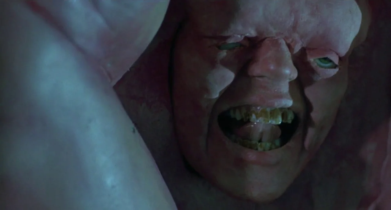 Hellraiser III: Hell on Earth movie still: closeup — A tight space surrounded by pale, organic, flesh-like membranes. A man's face emerges through…