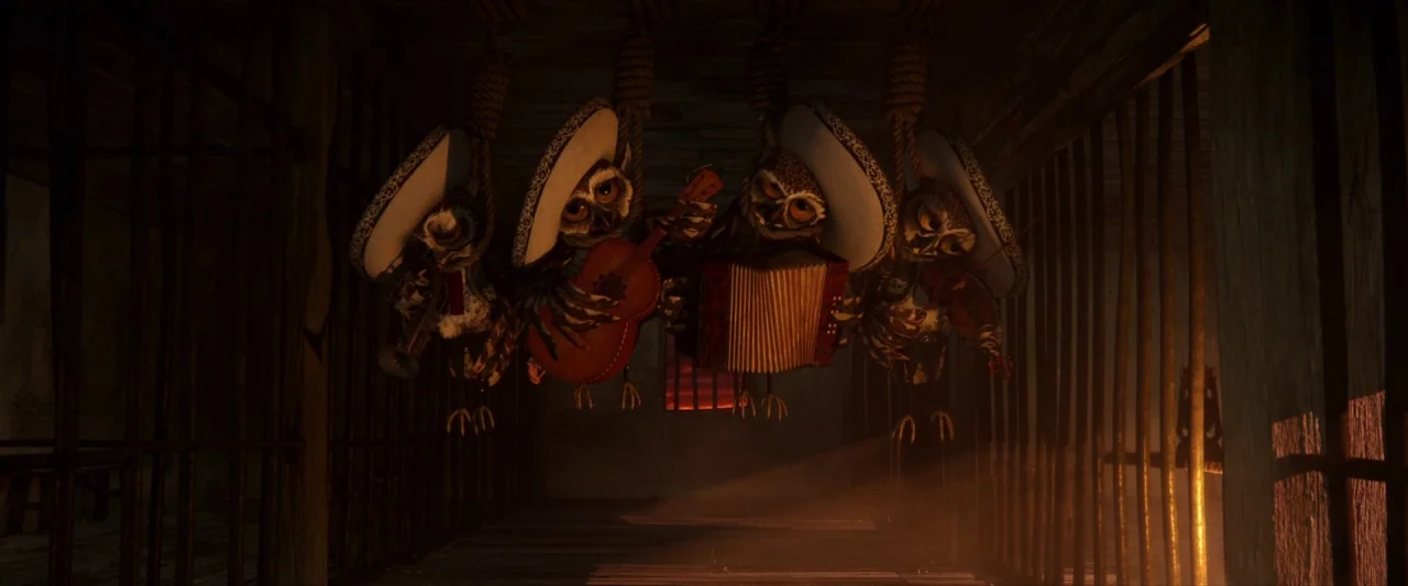 Rango (2011) movie still: medium — A dimly lit wooden jail with iron bars and hanging noose-like ropes. Four anthropomorphic owls wearing sombreros…