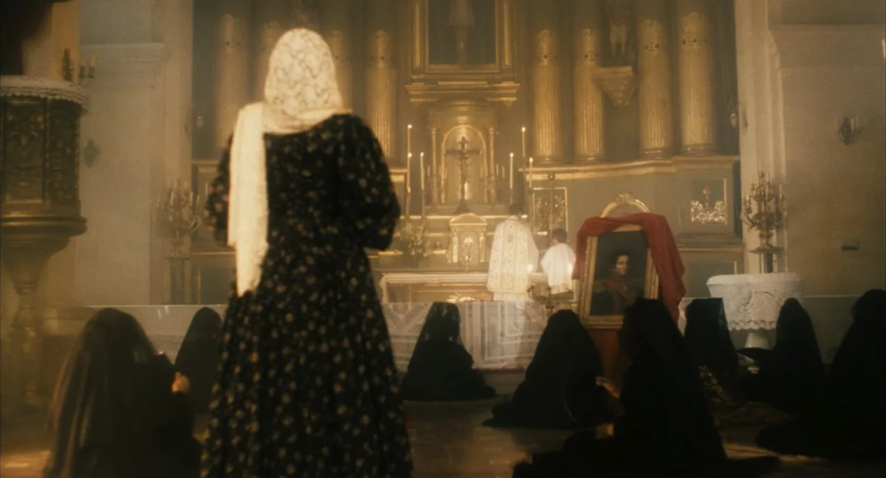 Camila (1984) movie still: fullbody — A dimly lit church interior features an ornate altar with candles and religious artifacts. A woman in a veil…