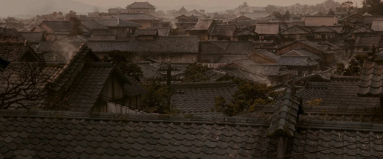 Memoirs of a Geisha (2005) movie still: establishing — A dense urban neighborhood of traditional houses features dark tiled roofs and winding…
