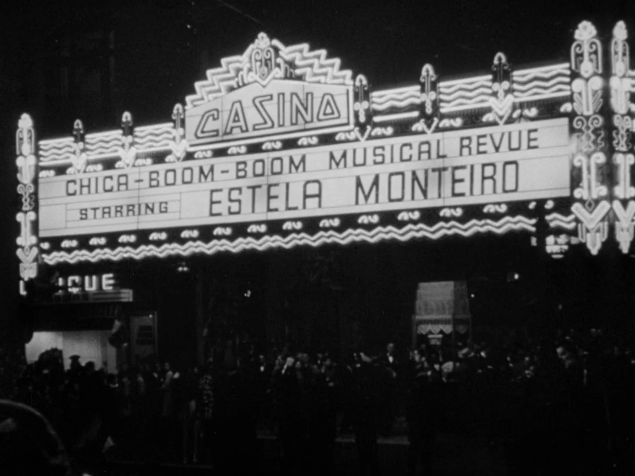 Phantom Lady (1944) movie still: establishing — A wide view of a large, brightly illuminated neon marquee for a casino theater. Text on the sign…