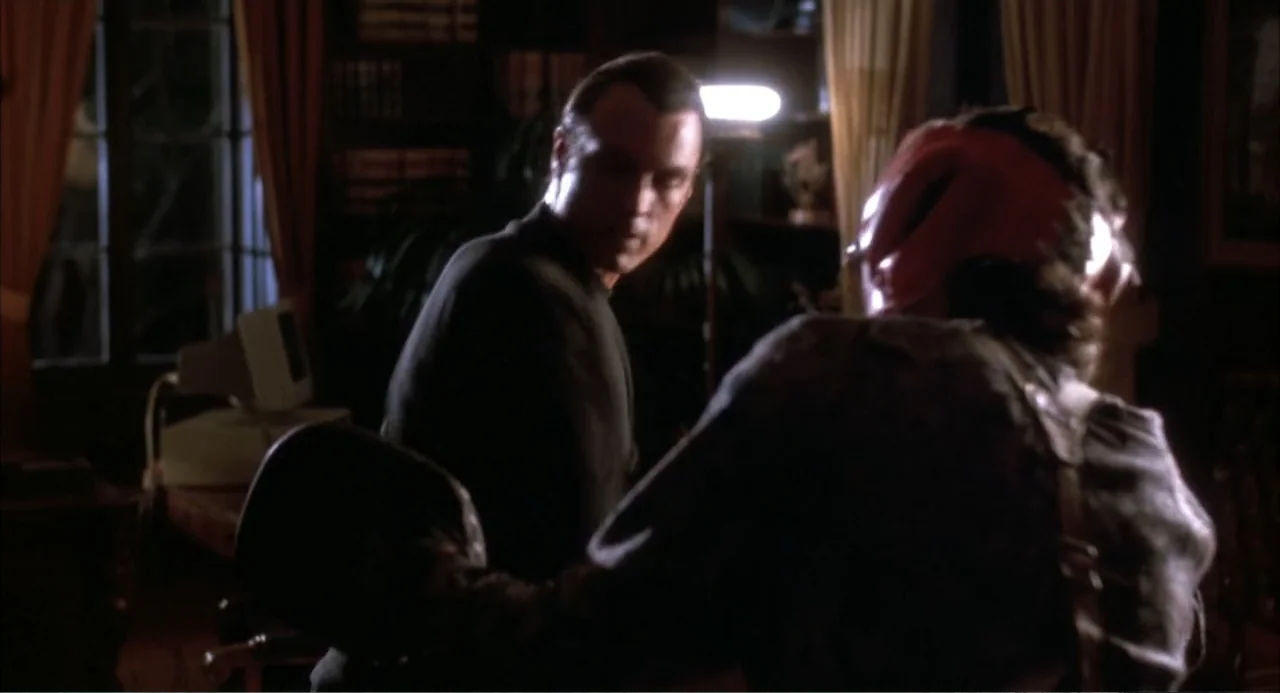 3 Ninjas (1992) movie still: medium — A dark study contains a desk with a computer and warm curtains at night. Two men stand in the foreground…
