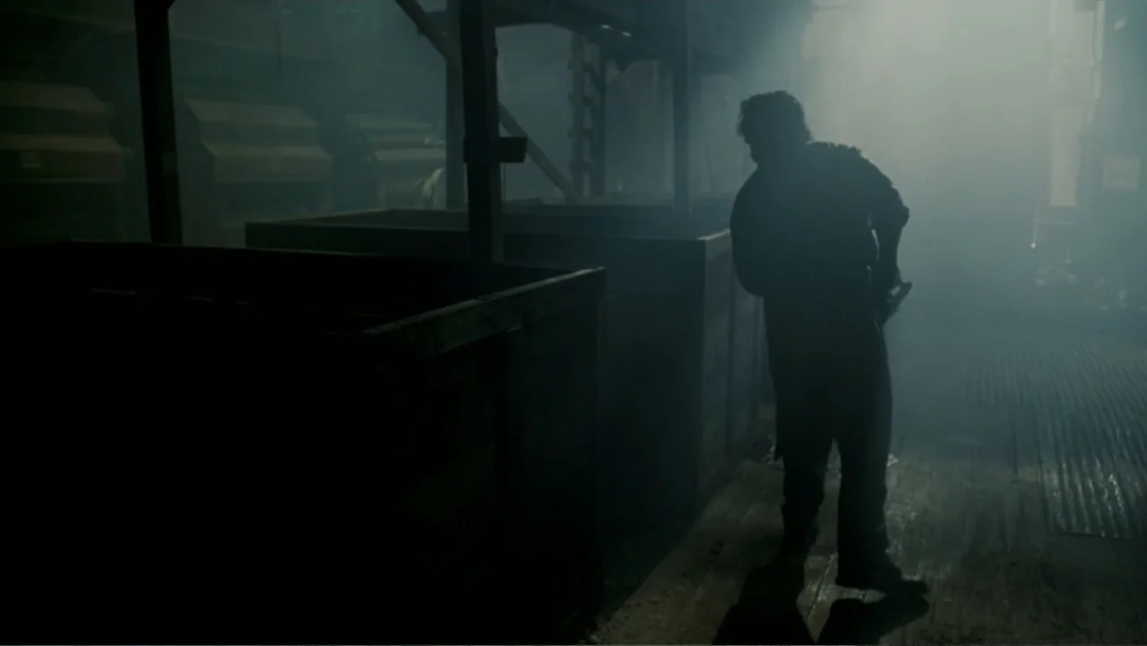 The Texas Chainsaw Massacre: The Beginning (2006) movie still: fullbody — A dark, smoke-filled industrial space contains several large wooden crates…