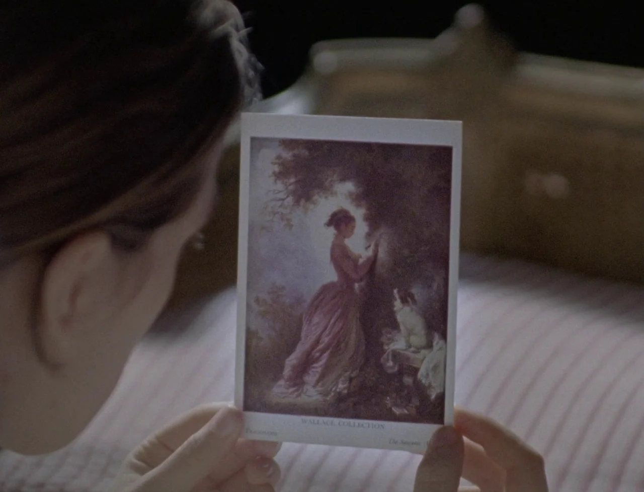 The Souvenir: Part II (2021) movie still: closeup — A person holds a small museum postcard depicting an eighteenth-century painting of a woman. The…
