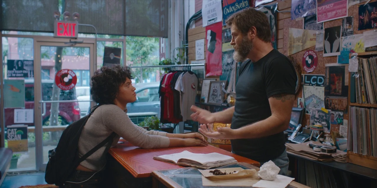 Hearts Beat Loud (2018) movie still: medium — A cluttered shop interior features walls covered in music posters and vinyl records. A woman stands at…