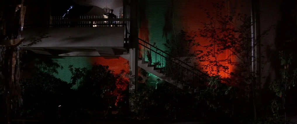 It Happened At The World’s Fair (1963) movie still: wide — An exterior apartment building at night features a staircase leading to an upper balcony.…