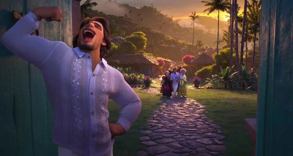 Encanto (2021) movie still: medium — A stone pathway leads through a vibrant village landscape during a golden sunset. A muscular man in a light…
