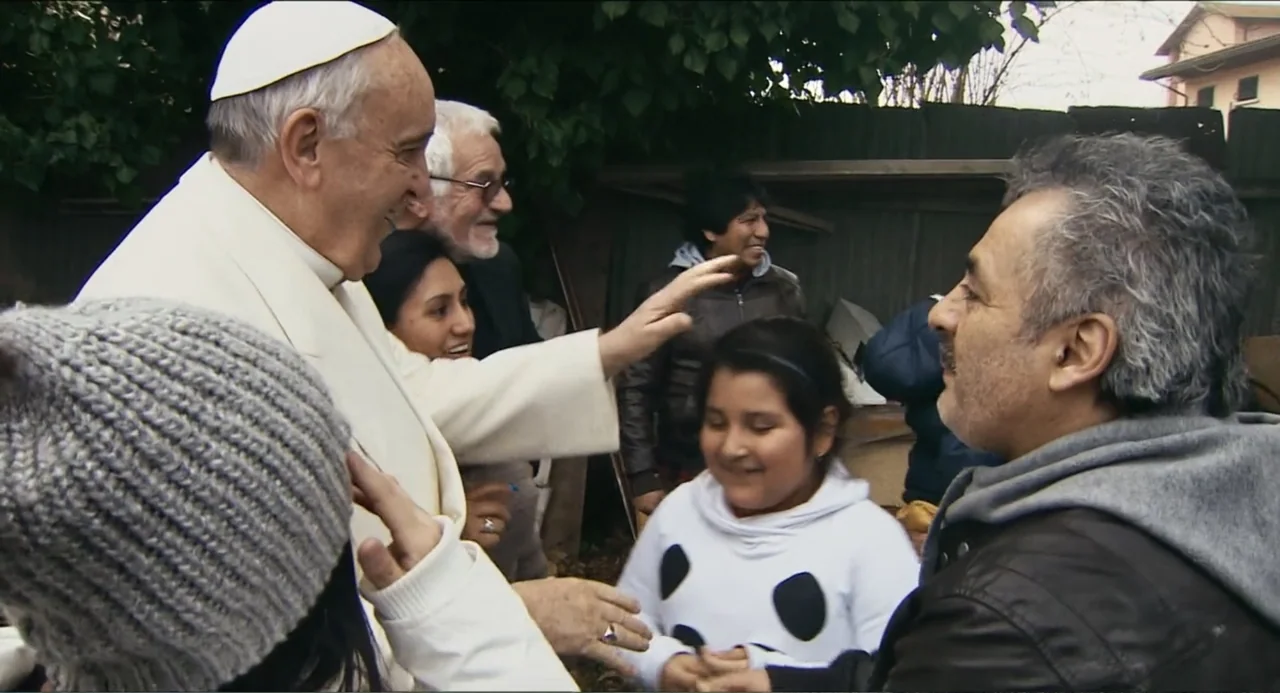 Pope Francis: A Man of His Word (2018) movie still: medium — A group of people gathers in a residential outdoor space with trees and fences. Pope…
