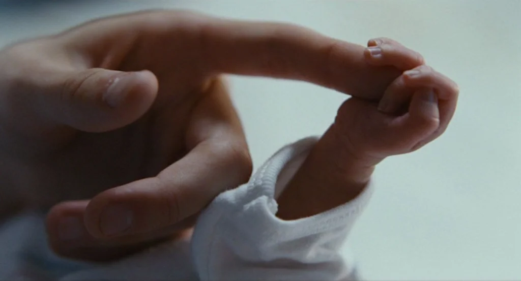 Louder Than Bombs (2015) movie still: An extreme close-up captures a profound moment of connection, as a baby's tiny hand gently grasps the index…