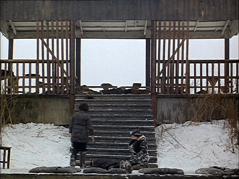 Mirror (Зеркало, Zerkalo) (1975) movie still: wide — A wooden pavilion stands at the top of concrete steps covered in light snow. Two women in…