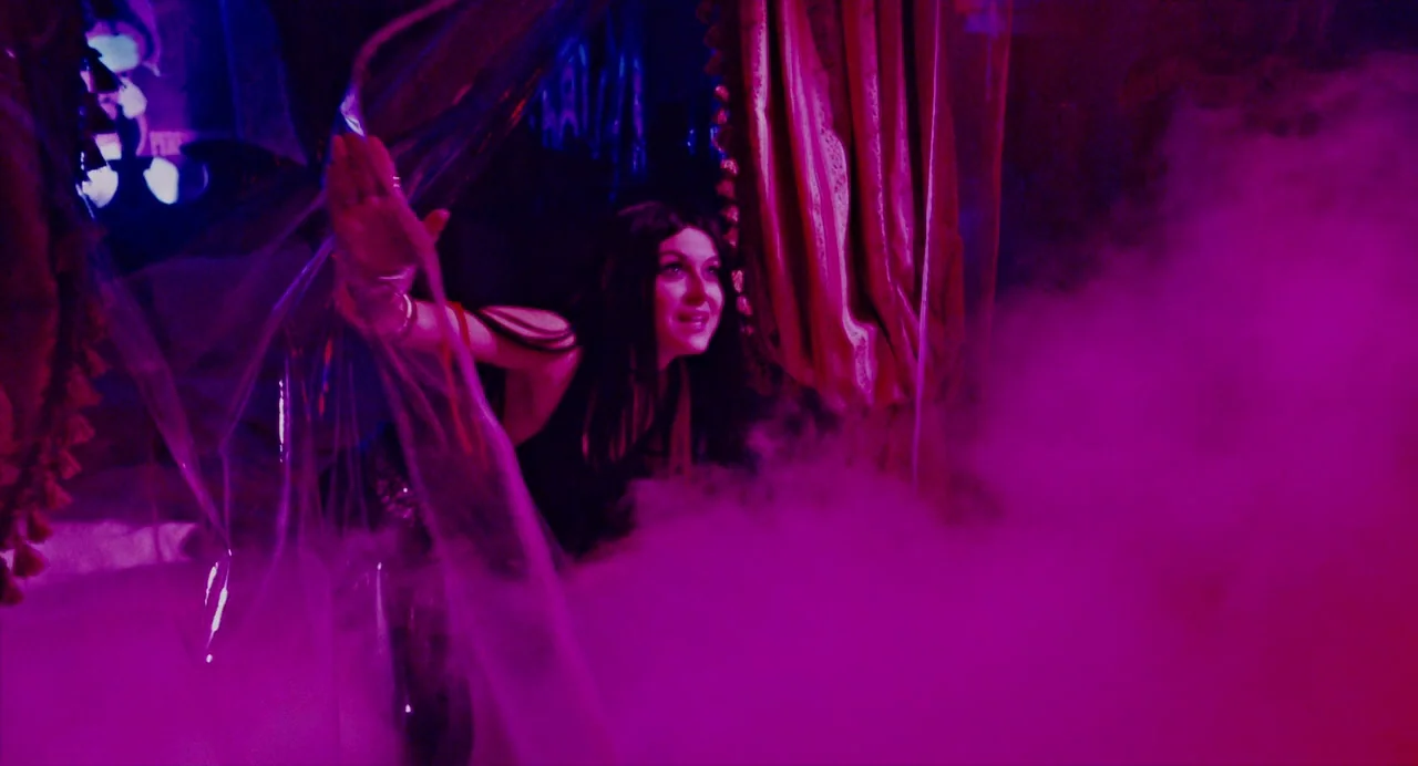Repo! The Genetic Opera (2008) movie still: medium — A woman stands behind a layer of translucent plastic on a dark stage. Thick magenta smoke fills…