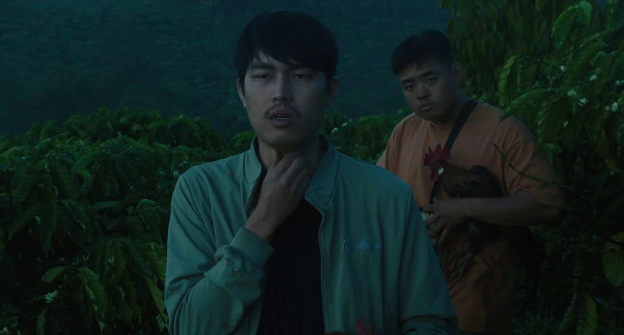 Inside The Yellow Cocoon Shell (2023) movie still: medium — An outdoor coffee plantation setting during twilight with dense green foliage in the…