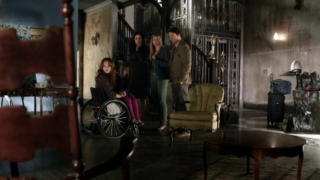 Curse of Chucky (2013) movie still: wide — A spacious, weathered foyer featuring a grand staircase and decorative metal ironwork detailing. Four…