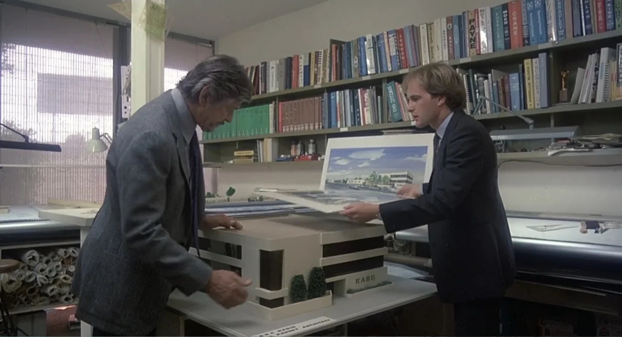 Death Wish II (1982) movie still: medium — An architectural office features floor-to-ceiling shelves packed with binders and technical documents.…
