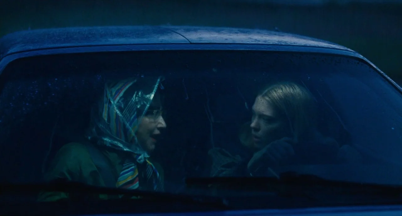 It’s Only The End Of The World (2016) movie still: medium — Two women are seated in the front seats of a dark car during a rainstorm. The windshield…