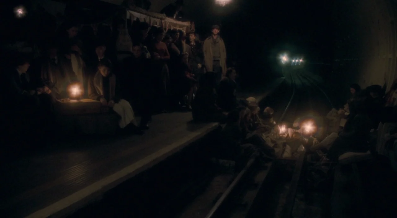 The Deep Blue Sea (2011) movie still: wide — A dark subterranean subway tunnel serves as a shelter for many people. Civilians huddle on the platform…