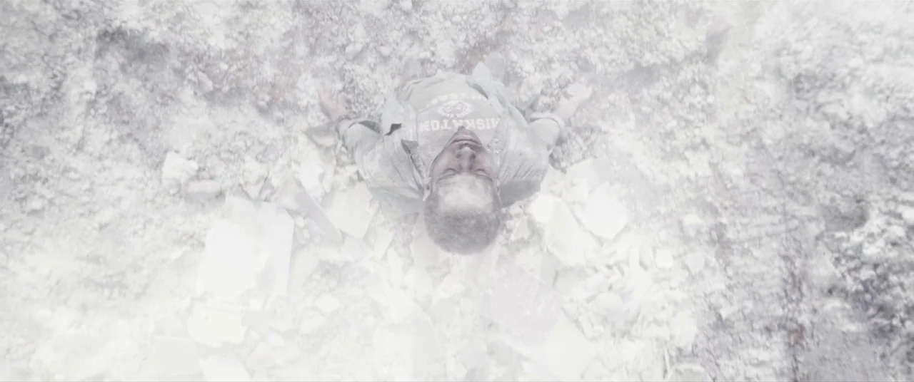 Colour Out of Space (2020) movie still: fullbody — A man lies on his back surrounded by scattered white concrete and construction dust. The…
