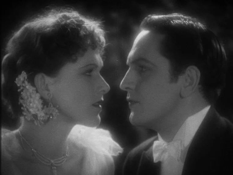 Dr. Jekyll and Mr. Hyde (1931) movie still: closeup — A formal interior space features a man and woman in evening attire. The two subjects face each…
