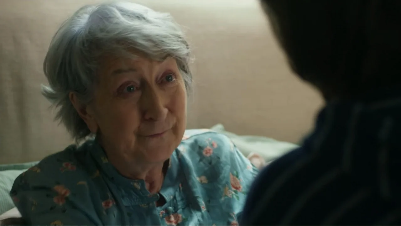A Scottish Love Scheme (2024) movie still: closeup — A bedroom interior features a light-colored wall and soft textures in the background. An…