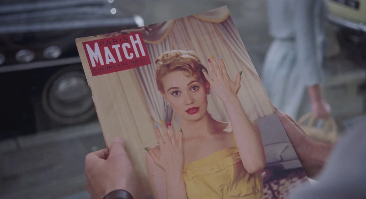 Populaire (2012) movie still: closeup — A close-up view of a person holding a July 1959 issue of Paris Match. The magazine cover features a portrait…