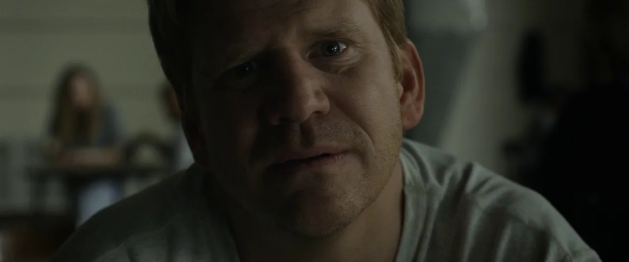 Before I Wake (2016) movie still: closeup — An interior space with a dimly lit foreground featuring a man's face. The background contains a…