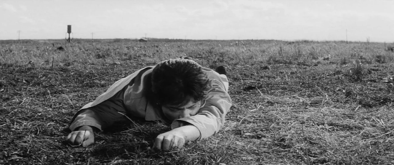 The Human Condition I: No Greater Love (1959) movie still: medium — An expansive, flat, and dry grassy field stretches toward a distant horizon…