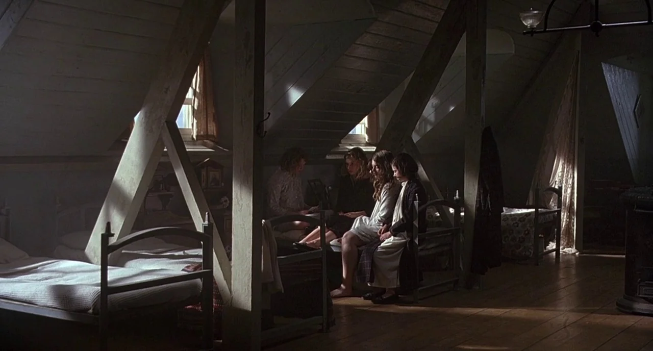 Cracks (2009) movie still: wide — An attic space featuring slanted ceilings, exposed wooden structural beams, and several single iron beds. Four…