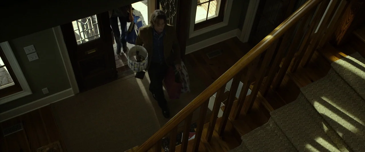 Before I Wake (2016) movie still: wide — A spacious home entryway features green walls, dark wood floors, and a wooden staircase. A man enters the…
