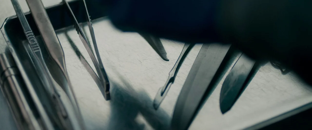 The Autopsy of Jane Doe (2016) movie still: closeup — A metal surgical tray holds various stainless steel instruments with visible surface…