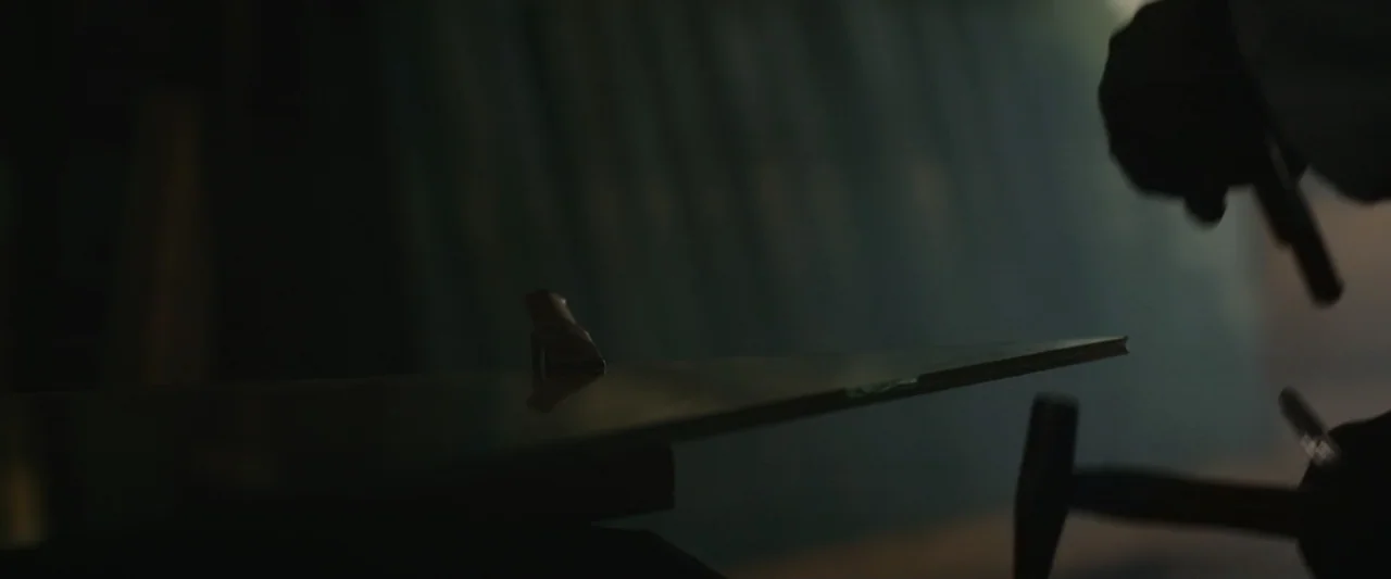 An emperor's jewel - The making of the Bulgari Hotel Roma (2024) movie still: closeup — A dark workshop interior features a metal blade held firmly…
