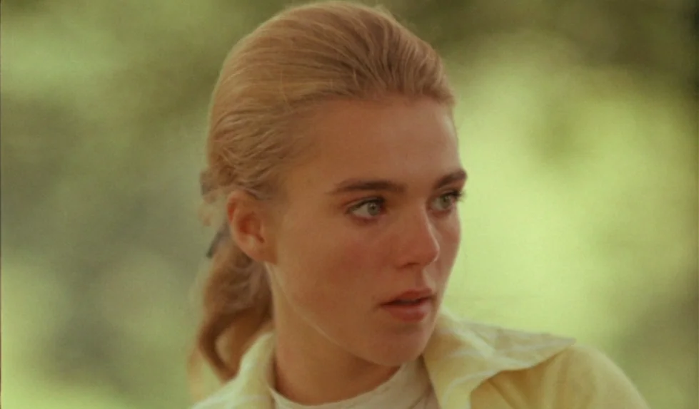 Elvira Madigan (1967) movie still: closeup — A woman stands in a sunlit outdoor area with blurred greenery in the background. She faces slightly to…