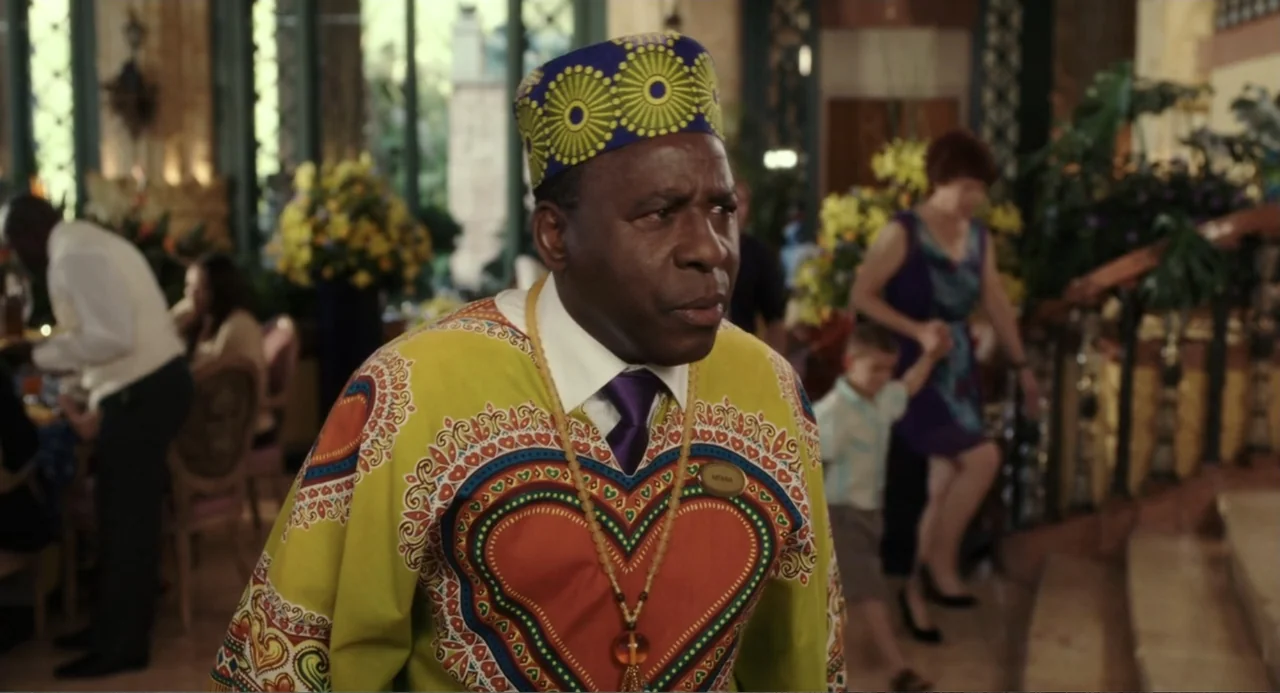 Blended (2014) movie still: medium — A well-lit upscale hotel lobby features ornate architectural details and floral displays in the background. A…