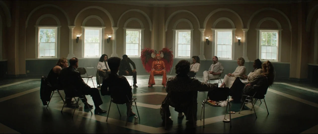 Rocketman (2019) movie still: wide — A circular room features arched windows and a teal and grey geometric floor pattern. A central figure in a…