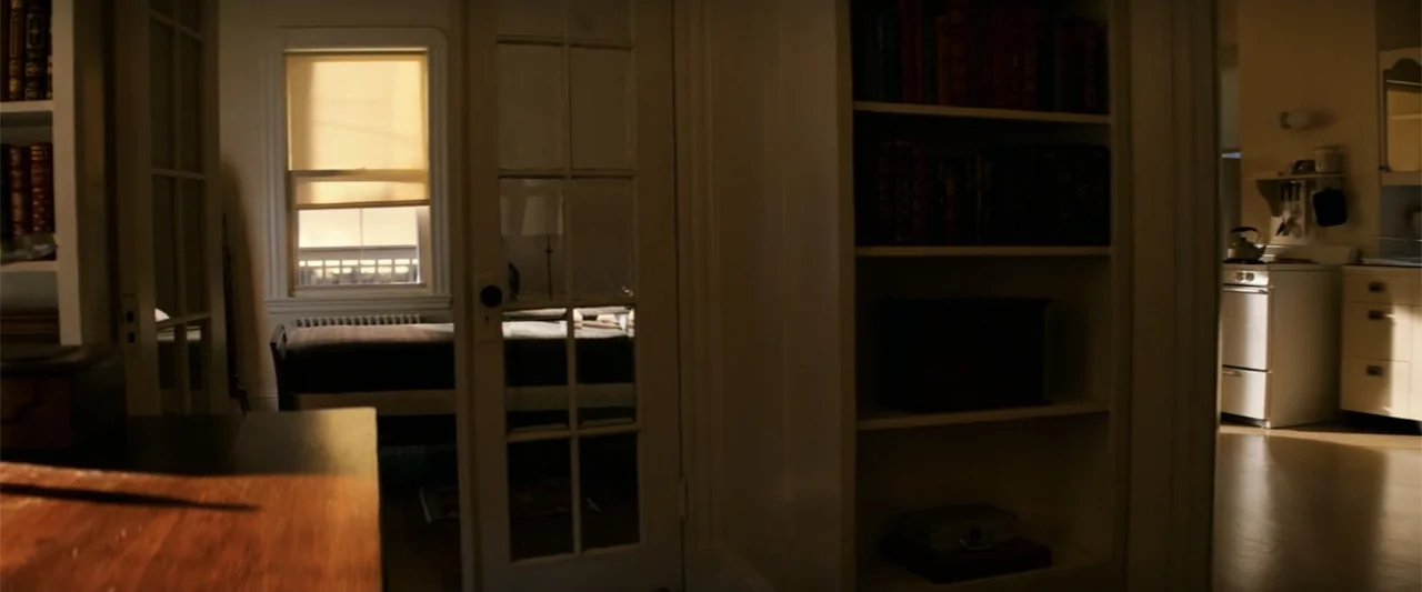 The Equalizer (2014) movie still: wide — A quiet apartment interior features white-painted shelves and a closed set of glass doors. An empty room…