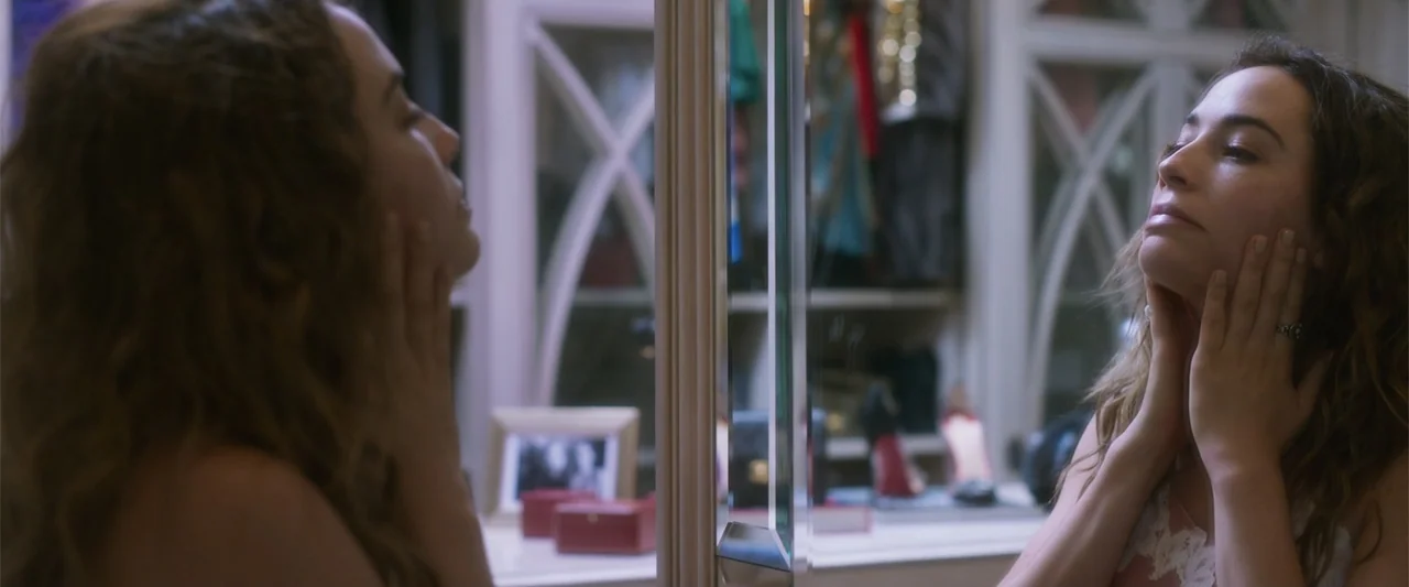Crazy for Change (2020) movie still: closeup — A well-lit dressing area with shelves displaying footwear and various small framed personal items. A…