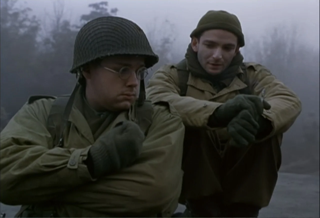When Trumpets Fade (1998) movie still: medium — A foggy, desolate outdoor location features two soldiers in military attire from the 1940s. One…