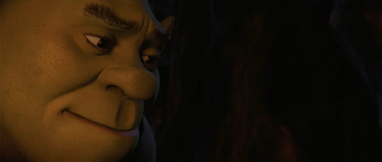 Shrek Forever After (2010) movie still: closeup — A close-up shot focuses on the green face of an ogre in a dimly lit environment. He looks…