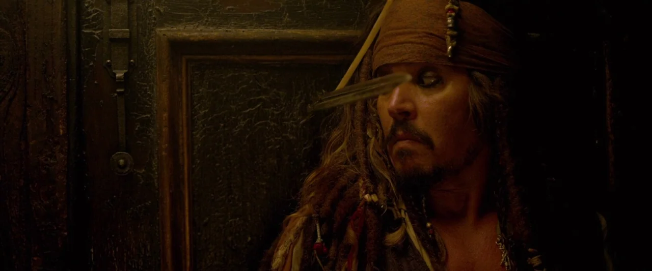 Pirates of the Caribbean: On Stranger Tides movie still: closeup — A dimly lit, wood-paneled space with dark finishes creates a confined,…