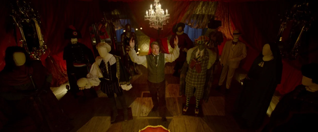 Paddington 2 (2017) movie still: fullbody — A dimly lit room filled with numerous headless mannequins dressed in elaborate historical costumes. A…