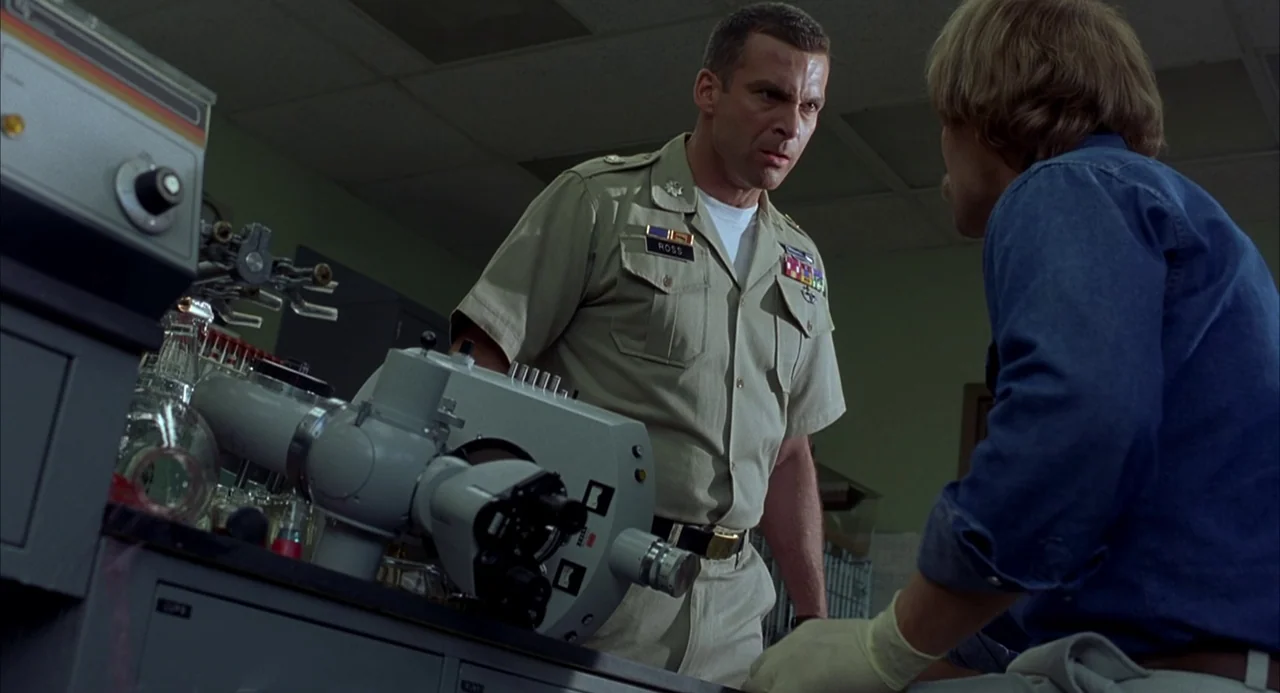 Hulk (2003) movie still: medium — A utilitarian laboratory space features clinical metal counters and specialized medical diagnostic machinery. A…